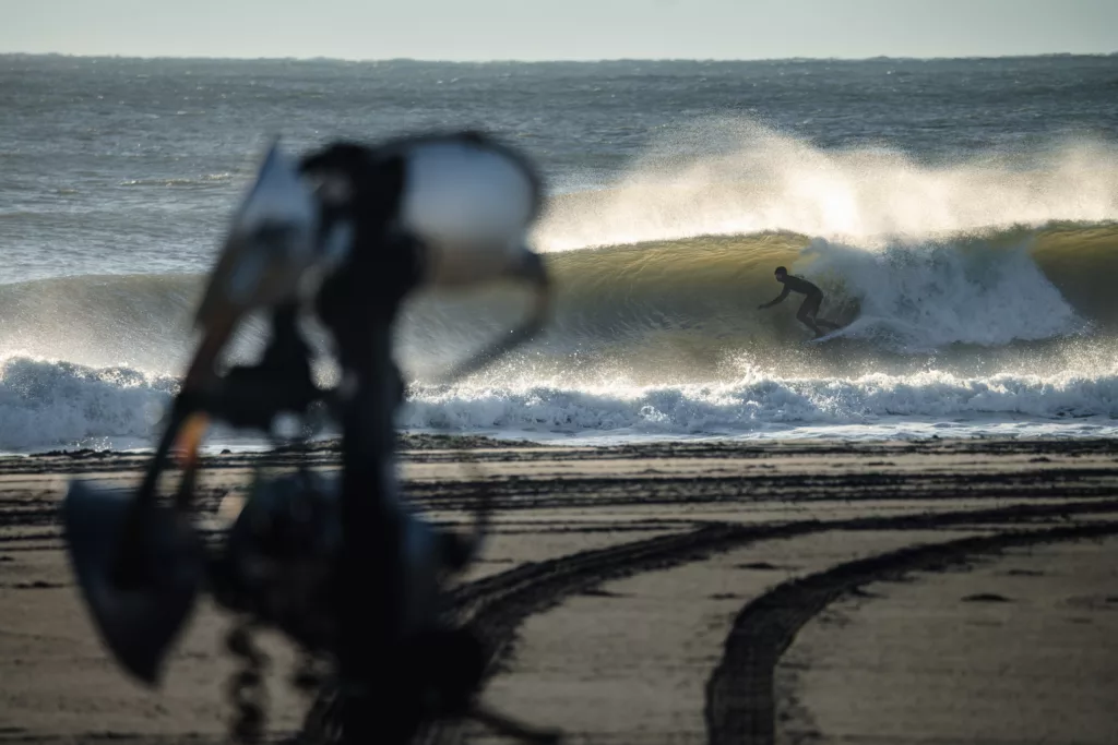 A surfer getting barreled in Ocean City New Jersey during dredging operation with construction equipment